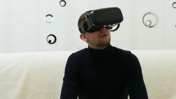 Man Using Virtual Reality Glasses at Home Journey in the Metaverse alt