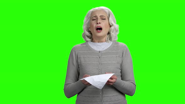Elderly Woman Sneezing on Green Screen Background alt