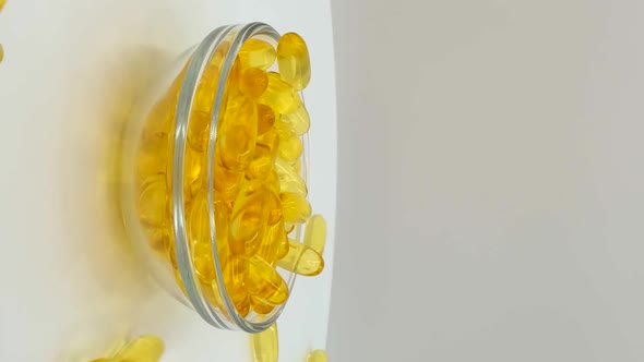 Vertical orientation video: Omega 3 (fish oil). Organic supplements vitamins yellow capsules alt