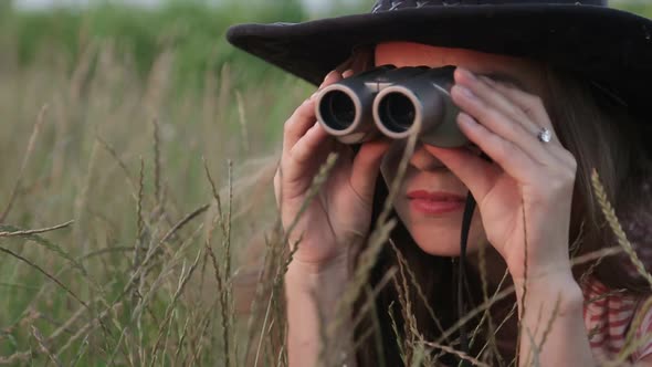 Beautiful Young Girl Looking Through Binoculars On Blue Sky Background. alt