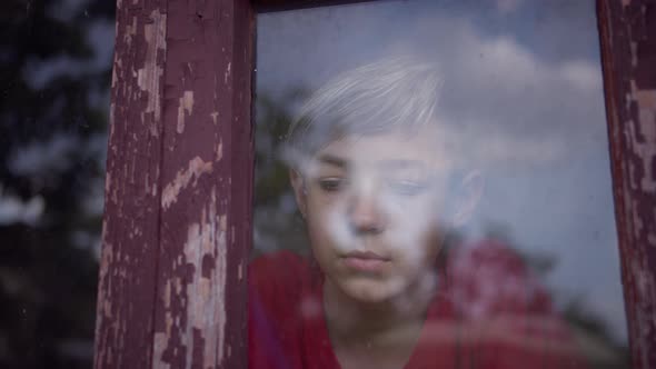 Funny Boy Looks Out the Old Shabby Window alt