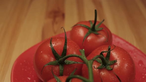 Ripe Fresh Tomatoes Branch Lies On Red Plate On The Table alt