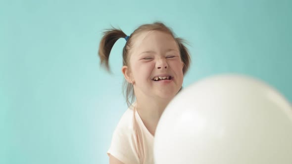 Girl with Down Syndrome Playing with Balloons alt