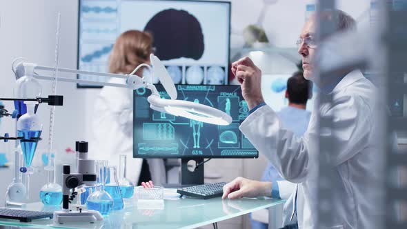 Mature Researcher or Doctor Using a Big Industrial Magnifying Glass alt