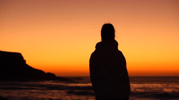 Silhouette view of a woman celebrating success at seaside at sunset in Fuerte