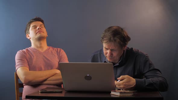 Son Sleeps on Chair While Senior Father Learns Use Computer alt