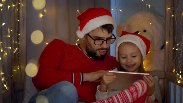Father and Girl Watch Cartoons on Tablet