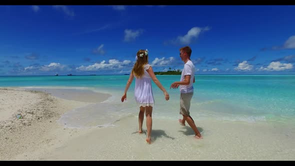 Man and lady sunbathing on paradise island beach wildlife by turquoise sea and white sandy backgroun alt