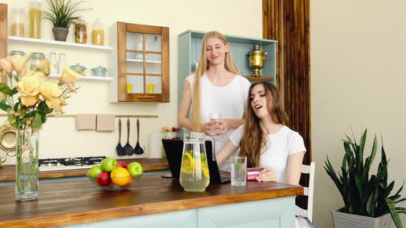 Two Cute Young Women Making Online Shopping, Finding And Discussing Goods alt