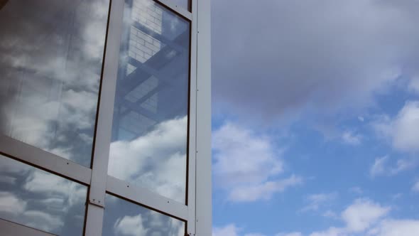 Timelapse of clouds on blue sky and as reflection on glass