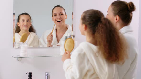 Happy Mother and Daughter Singing in Bathroom alt