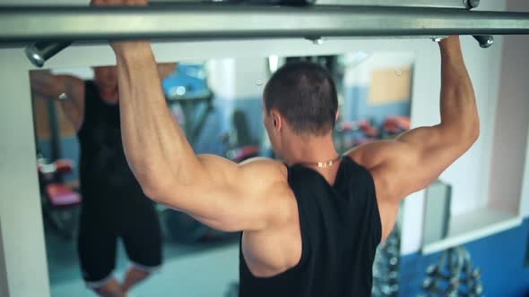 Athlete Doing Pullup on Horizontal Bar in the Gym alt