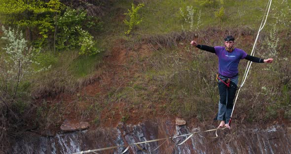 Sportsman Is Slacklining Over a Pit Extreme Sport Balance and Courage alt