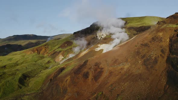 Steam coming out of the hills in Iceland showing geothermal power of Earth alt
