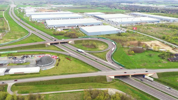 Aerial Shot of Industrial Warehouse Storage Building Loading Area where Many Trucks Are Loading Unlo alt