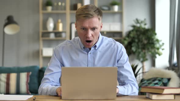 Businessman in Shock While Working on Laptop alt