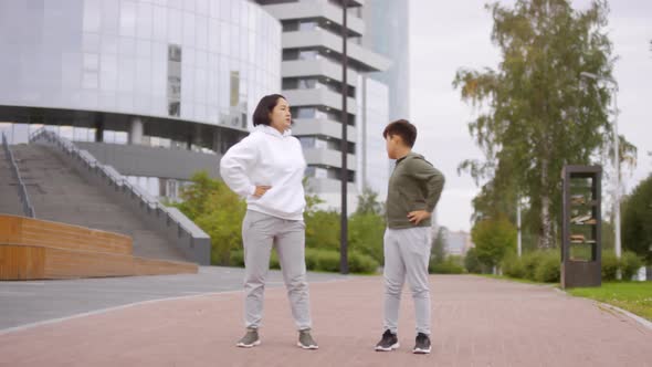 Asian Mother and Son Training Outdoors in City Center alt