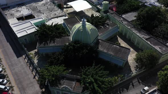 Aerial camera ascending from the side of and pitching down onto the colonial Church of Santiago Apos alt