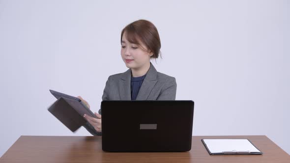 Young Happy Asian Businesswoman Multitasking at Work alt