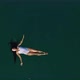 Top View of a Young Attractive Woman in a White Swimsuit Lying on the Water and Rowing with Her - VideoHive Item for Sale