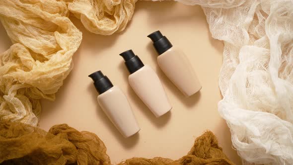 Bottles of Three Different Shades of Makeup Foundation on Beige