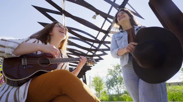 Friends Have Fun Enjoying Sound of Ukulele Music in Park