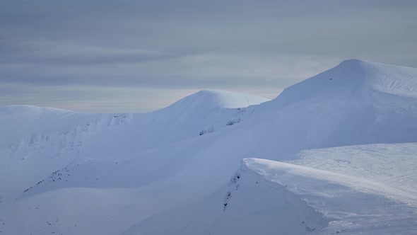 Panoramic View Over a Mountain Ridge Covered in Snow alt