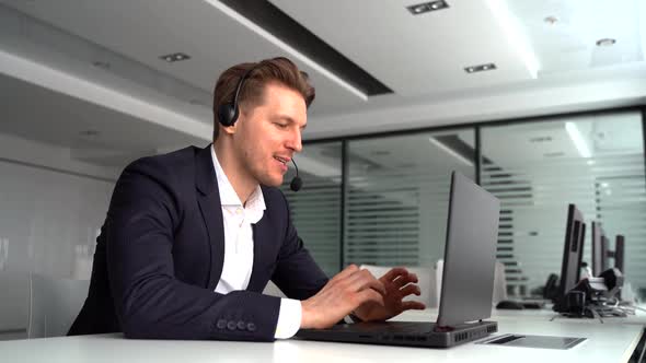 Millennial Caucasian Male Worker Have Video Call on Laptop in Office