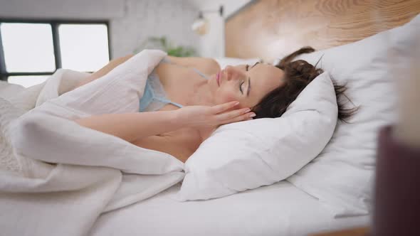 Beautiful Young Slim Caucasian Woman Sleeping in White Bed in the Morning alt