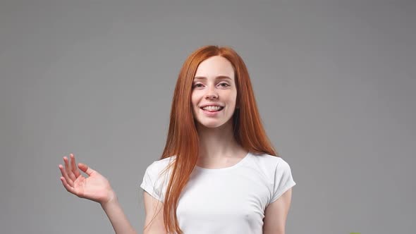 Portrait of Young Redhead Girl Holding Green Apple Looking at Camera and Smiling. Slow Motion