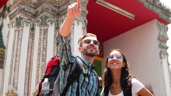 Young interracial couple tourist backpackers at Thai temple