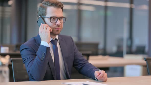 Businessman Talking on Phone in Office alt