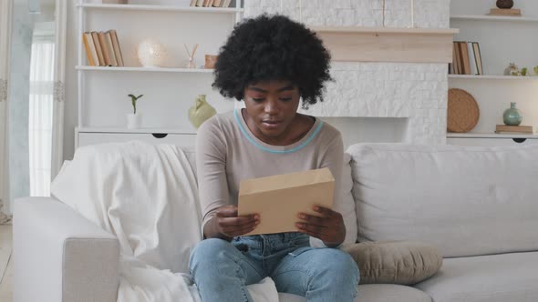 African Woman Opens Envelope Takes Out Paper Reading Notification Feels Frustrated and Shocked alt