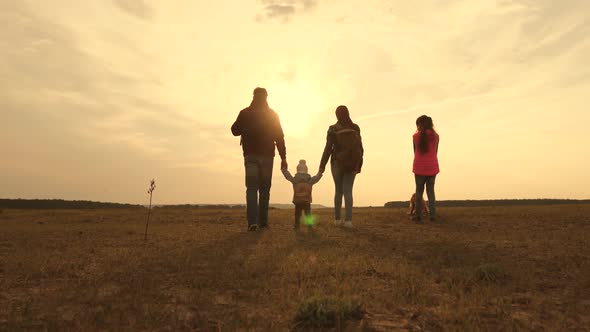 Dad, Mom, a Small Child and Daughters and Pets Tourists. Teamwork of a Close-knit Family alt
