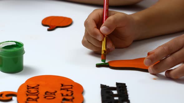 Children draw a pumpkin for Halloween. Needlework and preparation for the holiday. alt