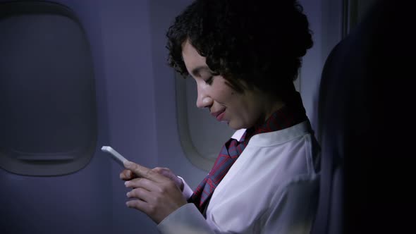 Flight attendant using cell phone at night