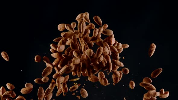 Raw Peeled Almonds Exploding Flying Up in Slow Motion, Isolated Black Background