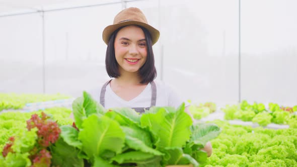 Portrait of Asian female farmer owner work in vegetables hydroponic greenhouse farm with happiness. alt