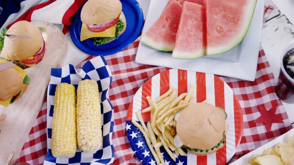 Hamburgers and french fries served on table with 4th july theme alt