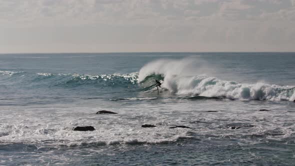 A surfer catches a nice wave off the coast of Australia and gets swallowed up by the whitewash befor alt