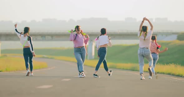 Fashionable Girls in Torn Jeans Dance in Summer