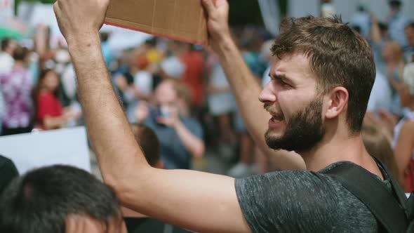 Bearded Angry Guy with Poster Sign Shouts in Crowd of Political Strike Activists