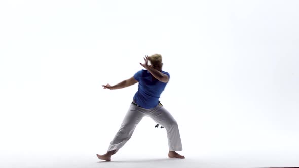 Man Practicing Capoeira in White Background of Studio. Afro-Brazilian Martial Art That Combine alt