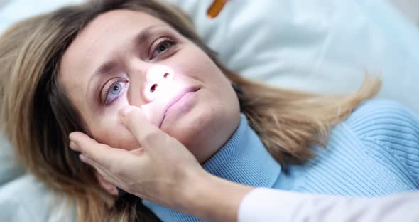 Healthcare Professional Shines Light Into Eyes of Lying Patient Slow Motion  Movie alt