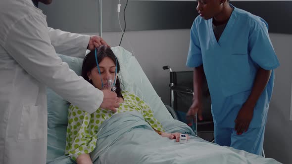 Patient Resting in Bed Having Respiratory Illness While Doctors Monitoring Heart Pulse alt