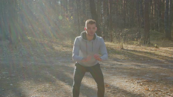 Caucasian Man Is Squatting In Forest