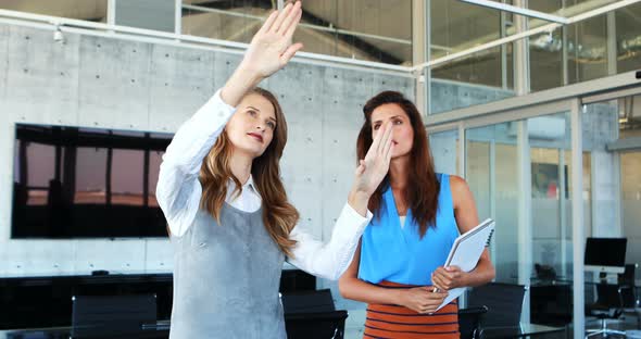 Female executives discussing on invisible screen alt