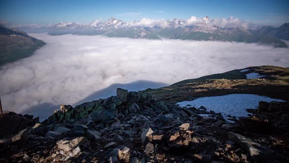 panoramic wide angle timelapse of a dynamic layer of morning fog moving in Oberengadin valley seen f alt