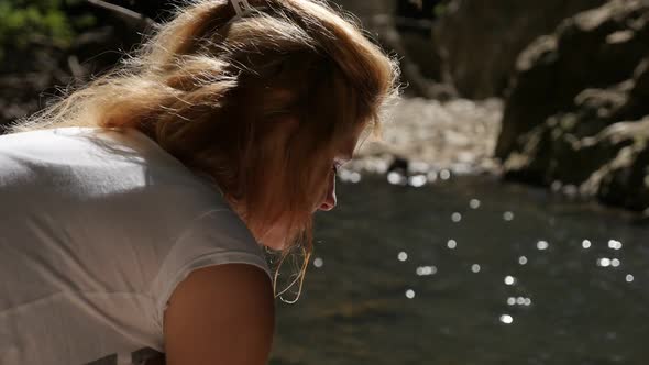 Woman drinks crystal clear water in slow motion 1080p FullHD footage - Blond female relaxing nearby 
