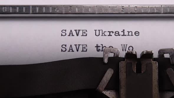 Typing phrase "SAVE Ukraine SAVE the World" on retro typewriter. alt